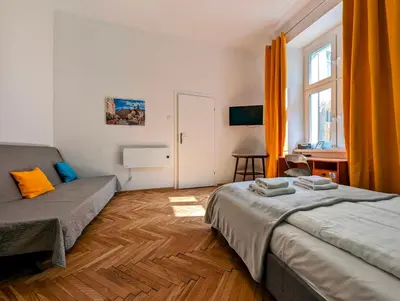 a bedroom with a bed and a couch and a window at Wiślna 4 by Homeprime in Kraków
