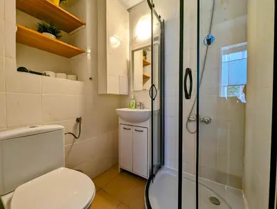 a bathroom with a toilet and a sink and a shower at Wiślna 4 by Homeprime in Kraków