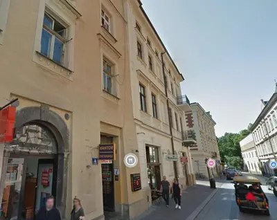 a group of people walking down a street next to buildings at Wiślna 4 by Homeprime in Kraków