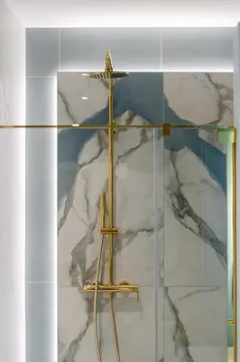 a cross on top of a white marble wall at Mostowa Street by Tyzenhauz in Kraków