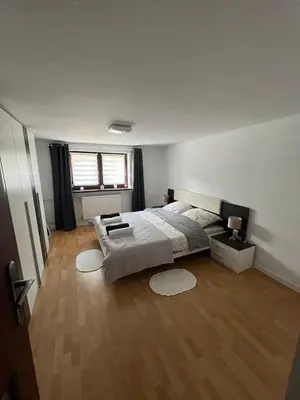 a bedroom with a large bed and a wooden floor at Apartament Koninki in Poręba Wielka