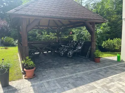 a wooden gazebo with a table and chairs at Apartament Koninki in Poręba Wielka