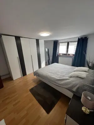 a bedroom with a large bed and a wooden floor at Apartament Koninki in Poręba Wielka