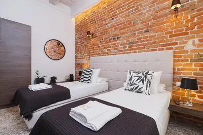two beds in a room with a brick wall at Apartment with balcony - Rakowicka 6 Street in Kraków