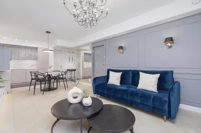a living room with a blue couch and a table at Augustianska - Private parking - Kazimierz District in Kraków