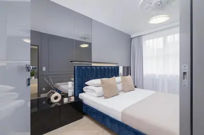 a bedroom with a bed with a blue headboard at Augustianska - Private parking - Kazimierz District in Kraków