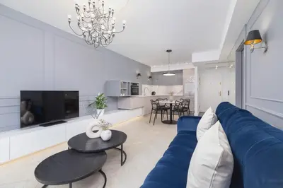 a living room with a blue couch and a table at Augustianska - Private parking - Kazimierz District in Kraków