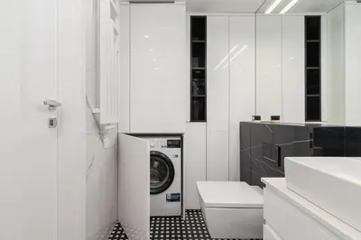 a white bathroom with a washer and dryer in it at Augustianska - Private parking - Kazimierz District in Kraków