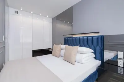 a bedroom with a white bed with a blue headboard at Augustianska - Private parking - Kazimierz District in Kraków