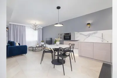 a kitchen and living room with a table and chairs at Augustianska - Private parking - Kazimierz District in Kraków