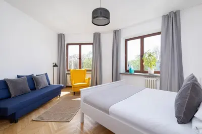a bedroom with a bed and a blue couch at 3 bedroom apartment-Aleja Daszyńskiego- Grzegórzki in Kraków