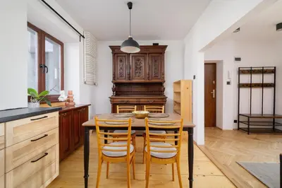 a kitchen with a wooden table and chairs at 3 bedroom apartment-Aleja Daszyńskiego- Grzegórzki in Kraków