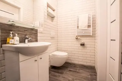 a white bathroom with a sink and a toilet at 1-bedroom apartment - Kazimierz- Starowiślna 54 in Kraków