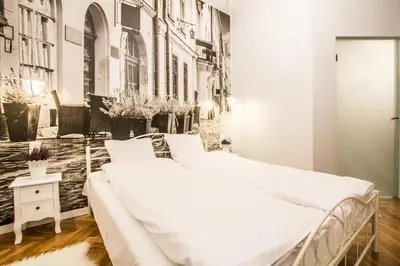 a bedroom with a large white bed and a wall with buildings at 1-bedroom apartment - Kazimierz- Starowiślna 54 in Kraków
