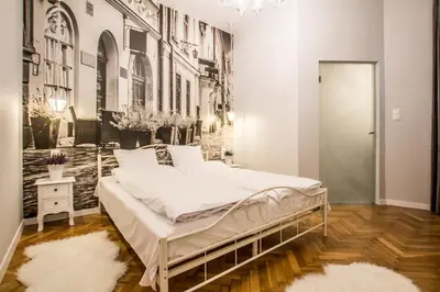a bed in a room with a wall mural at 1-bedroom apartment - Kazimierz- Starowiślna 54 in Kraków