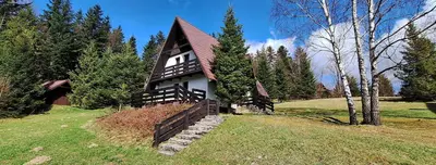 a black and white house in a field with trees at Spokojny Domek w Skawicy in Skawica