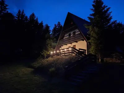 a barn with lights on the side of it at night at Spokojny Domek w Skawicy in Skawica
