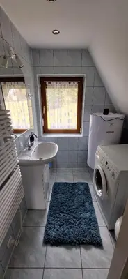 a bathroom with a sink and a washing machine at Spokojny Domek w Skawicy in Skawica