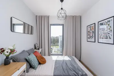 a bedroom with a bed and a window at RentPlanet - Apartamenty Aura Prandoty in Kraków