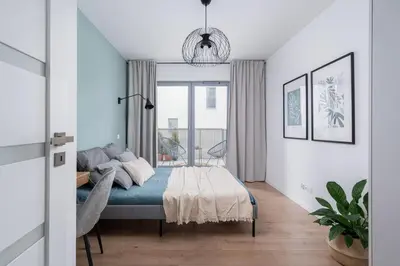 a bedroom with a bed and a large window at RentPlanet - Apartamenty Aura Prandoty in Kraków