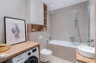 a bathroom with a sink and a washing machine at RentPlanet - Apartamenty Aura Prandoty in Kraków