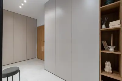 a room with a white wall and a black chair at RentPlanet - Apartamenty Aura Prandoty in Kraków