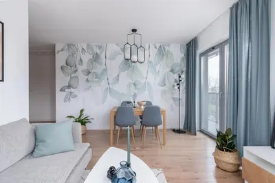 a living room with a couch and a table with chairs at RentPlanet - Apartamenty Aura Prandoty in Kraków
