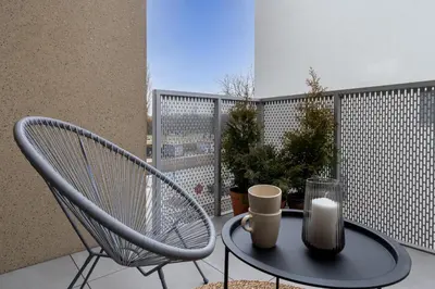 a chair and a table with a candle on a balcony at RentPlanet - Apartamenty Aura Prandoty in Kraków