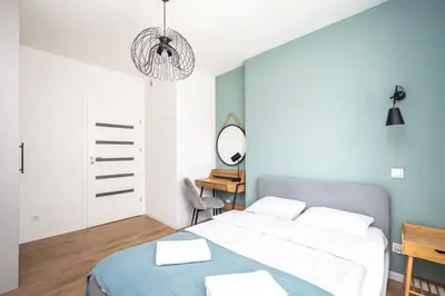 a bedroom with a bed and a mirror at RentPlanet - Apartamenty Aura Prandoty in Kraków