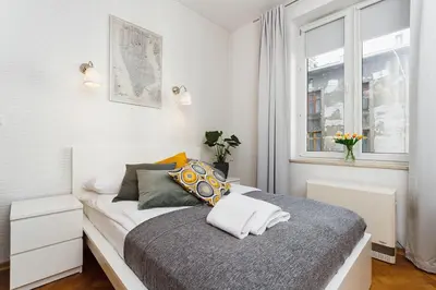 a small bedroom with a bed with a window at Studio Apartment - Rzeszowska 4 Street in Kraków