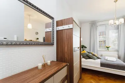 a small bedroom with a bed and a mirror at Studio Apartment - Rzeszowska 4 Street in Kraków