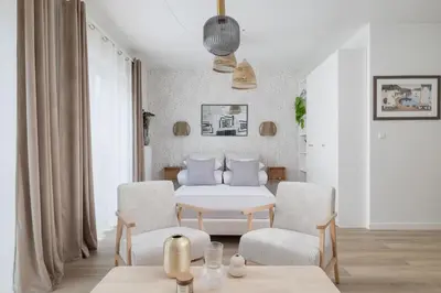 a white room with a bed and two chairs at Luxury Studio with an AC - Lwowska 10 street in Kraków