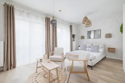 a white bedroom with a bed and a table at Luxury Studio with an AC - Lwowska 10 street in Kraków