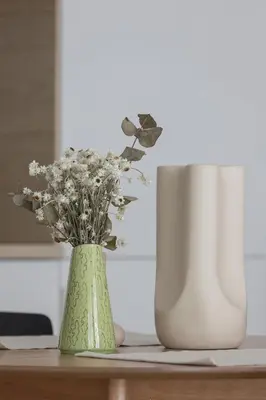 a green vase with flowers sitting on a table at Luxury Studio with an AC - Lwowska 10 street in Kraków