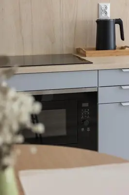 a black microwave oven sitting on a counter in a kitchen at Luxury Studio with an AC - Lwowska 10 street in Kraków