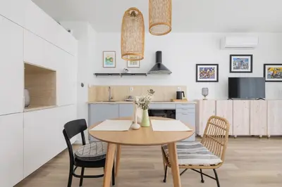 a kitchen and dining room with a wooden table and chairs at Luxury Studio with an AC - Lwowska 10 street in Kraków