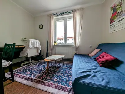 a bedroom with a blue bed and a desk and a window at Urzędnicza 23 by Homeprime in Kraków