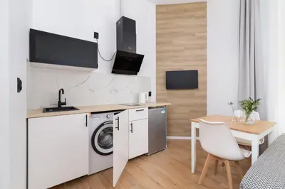 a small kitchen with a washing machine and a table at Studio Apartment - Radziwiłłowska 27 in Kraków