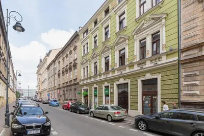 a street with cars parked in front of buildings at Studio Apartment - Radziwiłłowska 27 in Kraków