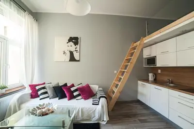 a bedroom with a bed with pink pillows and a ladder at Apartment in the centre - Old Town in Kraków