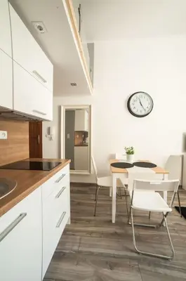 a kitchen with a table and a clock on the wall at Apartment in the centre - Old Town in Kraków
