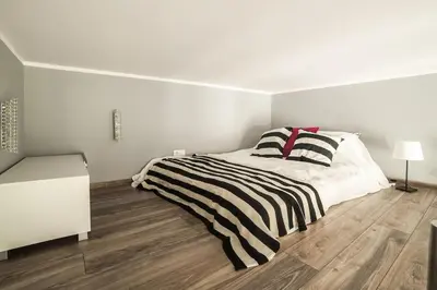 a white bedroom with a bed with a black and white striped blanket at Apartment in the centre - Old Town in Kraków