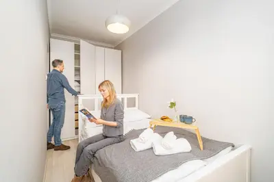 a white bathroom with a toilet and a shower at Lovely Old City, Kazimierz apartment - by Hosty in Kraków
