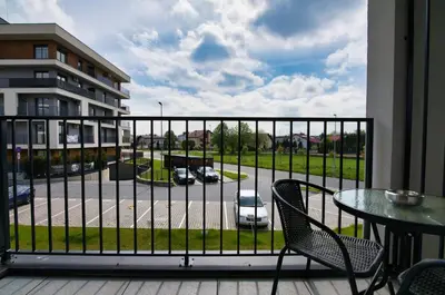 a balcony with a table and chairs and a view of a parking lot at Apartament Venus by Housine in Zator