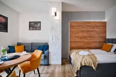 a bedroom with a bed and a table and a couch at Apartament Mars by Housine in Zator