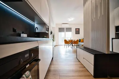 a kitchen with white cabinets and a dining room at Apartament Mars by Housine in Zator