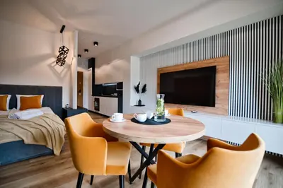 a living room with a table and chairs and a bed at Apartament Mars by Housine in Zator