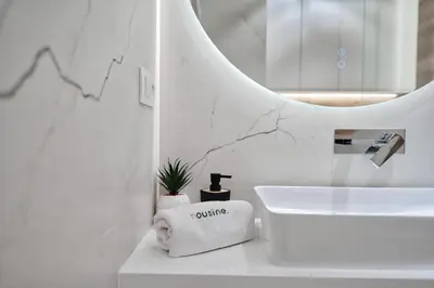 a white bathroom with a sink and a mirror at Apartament Mars by Housine in Zator