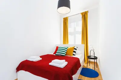 a bedroom with a bed with a red blanket at Apartment for two Krakowska 16 Street in Kraków