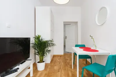 a living room with a white table and blue chairs at Apartment for two Krakowska 16 Street in Kraków